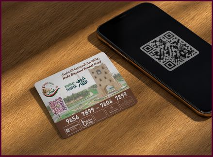 بطاقة هلا بجانب هاتف يعرض رمز QR